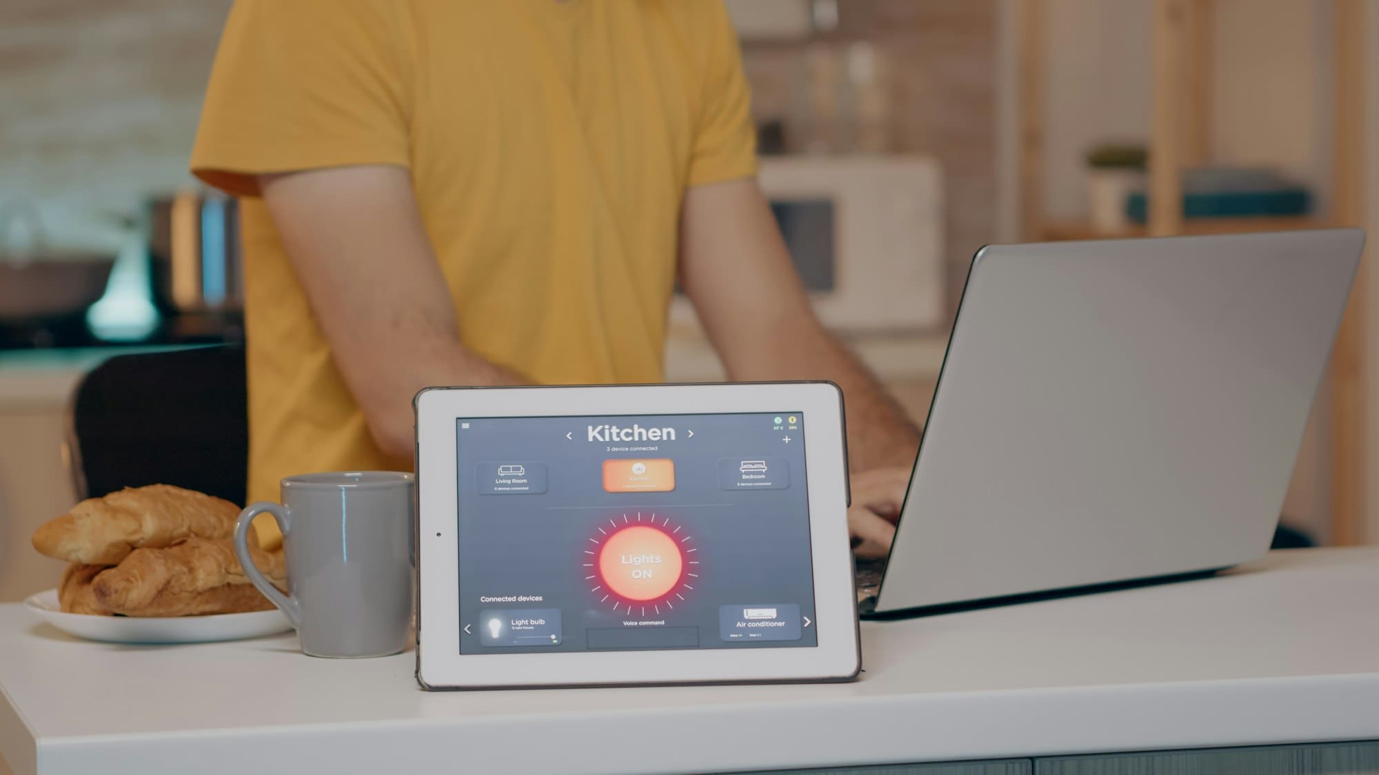 Male typing on laptop working from home with automation lighting system