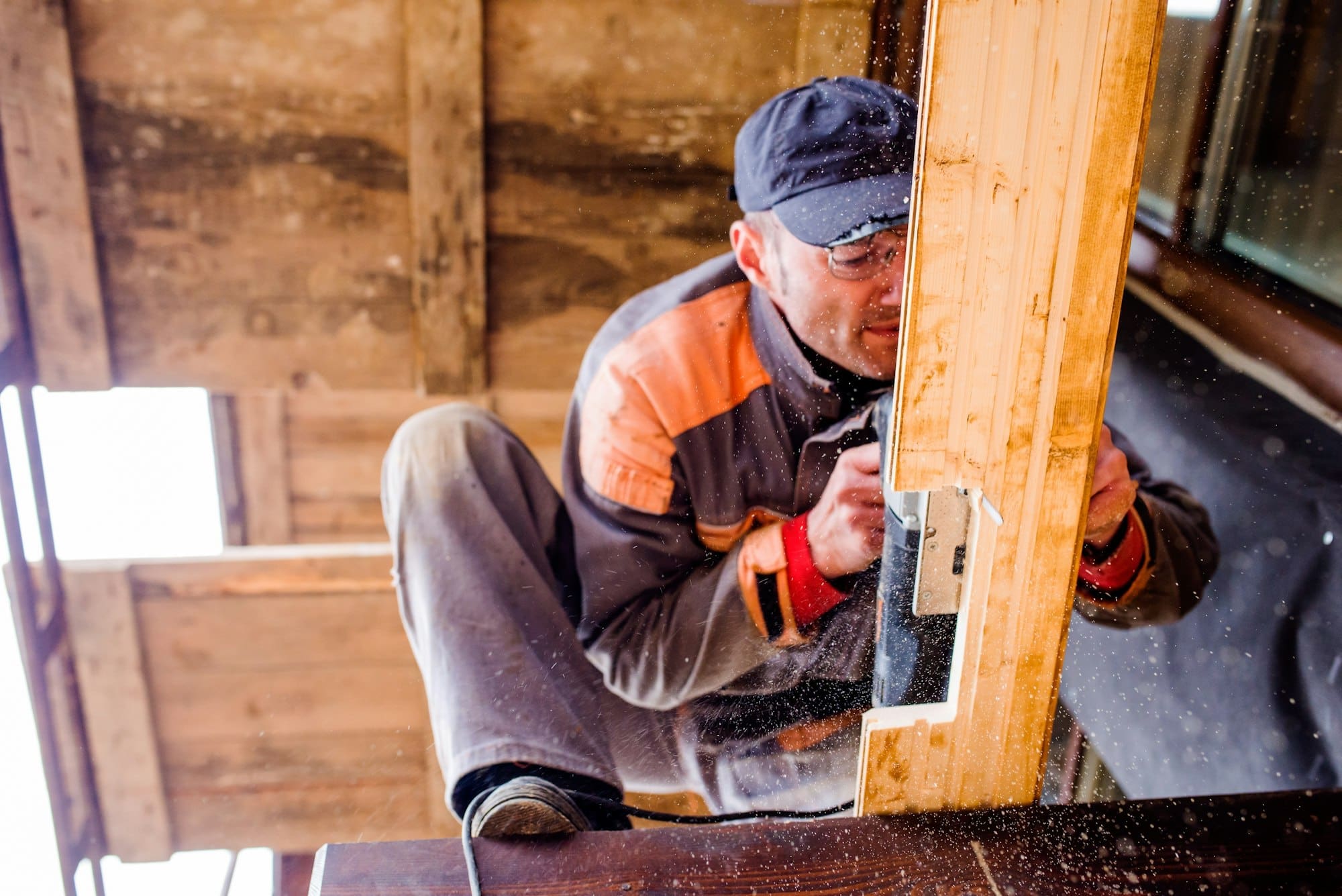 Man grinding planks of wood for home construction.